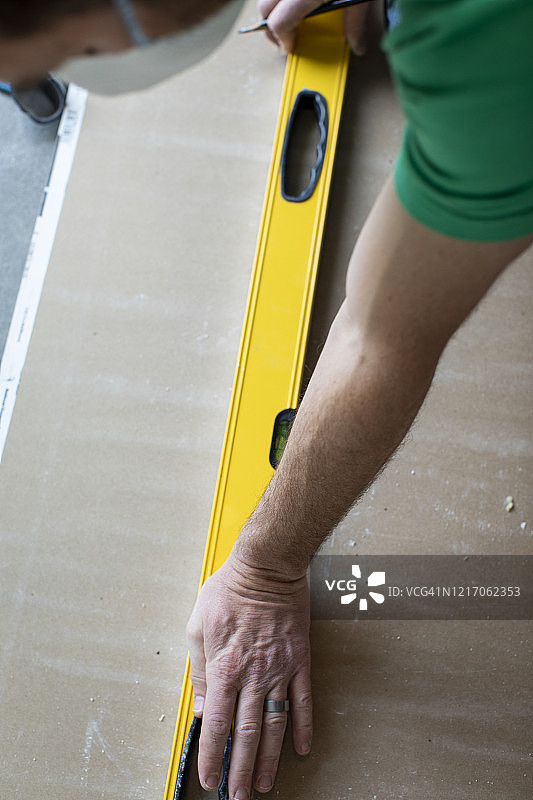 男人在石膏板上使用水平仪图片素材