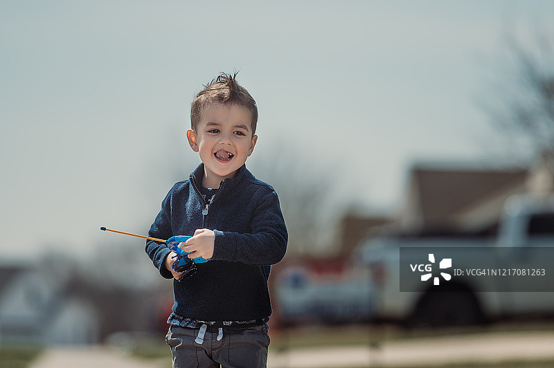 疫情期间独自在户外玩玩具的3岁半幼儿图片素材