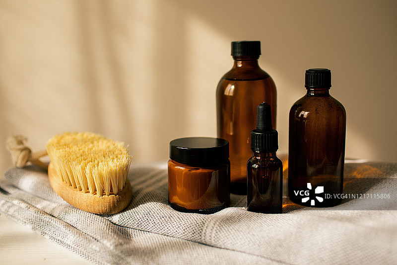 琥珀色玻璃瓶化妆品精油，配米色背景抗脂肪刷图片素材