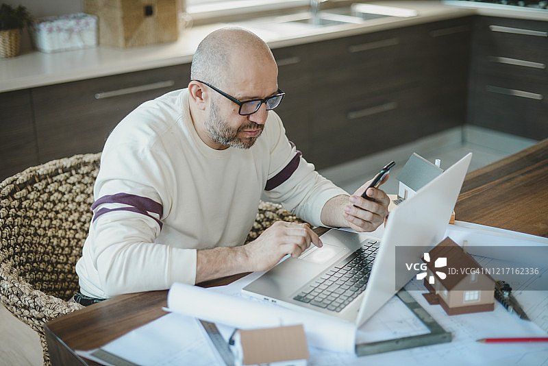 年长的男人在家工作（使用手机）图片素材