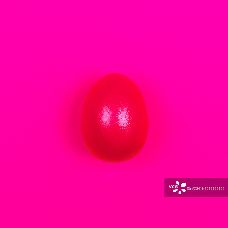 粉色霓虹背景上的紫色彩蛋图片素材