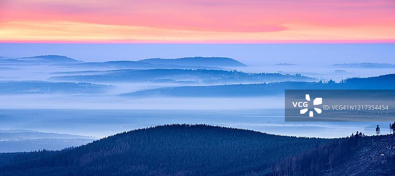 德国萨克森-安哈尔特州哈尔茨国家公园布罗肯山的日出，山丘森林和山谷雾景图片素材