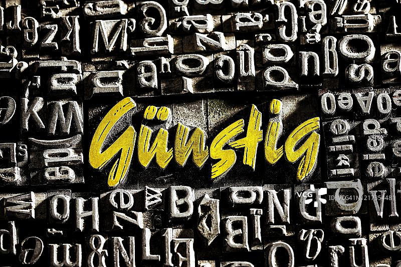 带有金色文字的旧铅字，显示单词guenstig，德国图片素材