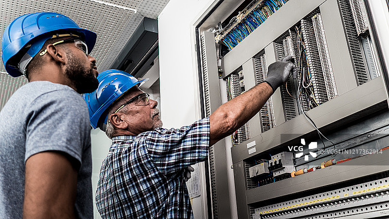 正在查看配电板的两位电工图片素材