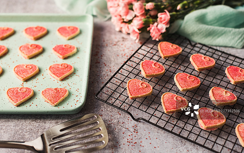 粉色情人节心形饼干在烤盘和架子上冷却图片素材