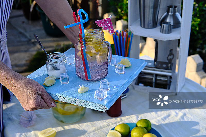 女服务员用蓝色木制托盘端着鸡尾酒图片素材