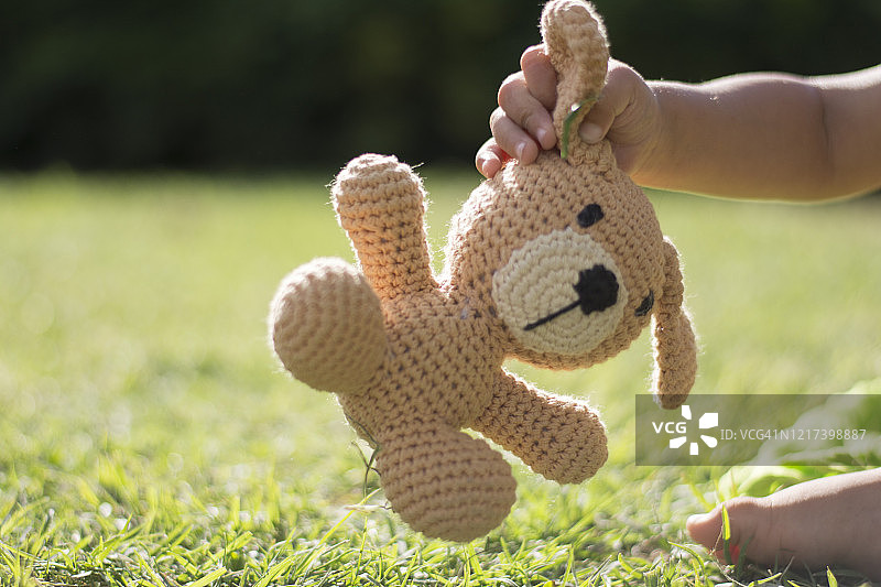 男孩在公园抱着毛绒玩具图片素材