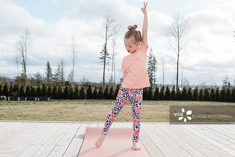 在家后院伸展做瑜伽的年轻女孩图片素材
