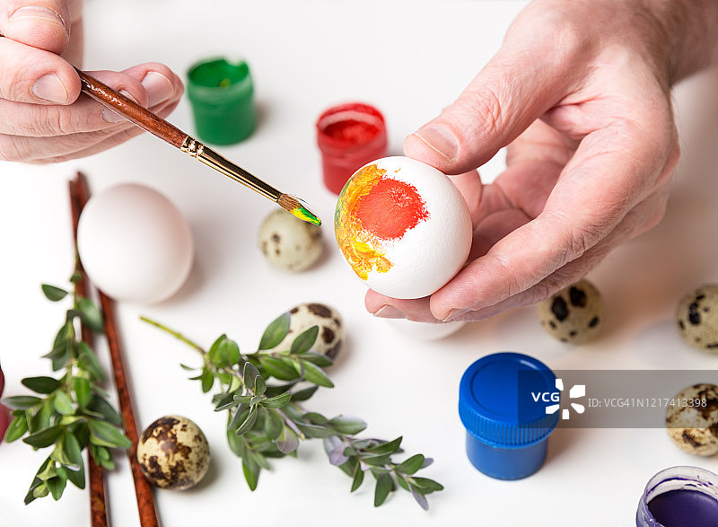 男人用刷子绘制复活节彩蛋，准备迎接复活节图片素材