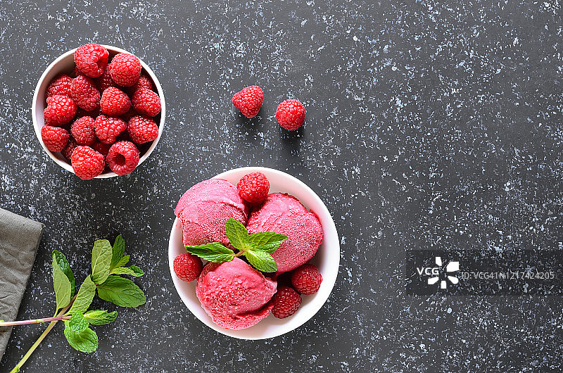 覆盆子冰淇淋勺与新鲜覆盆子和新鲜浆果在碗里图片素材