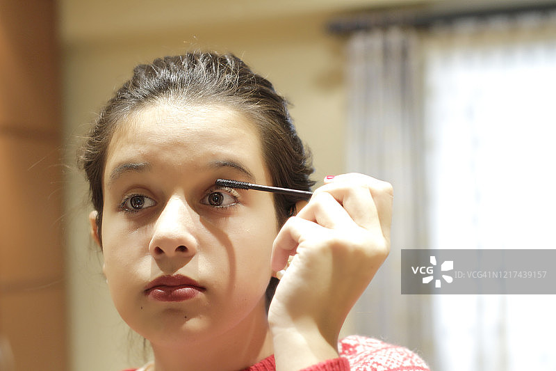 青少年女孩涂睫毛膏图片素材