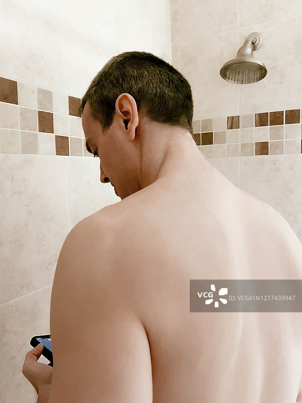 淋浴时查看手机的男人图片素材