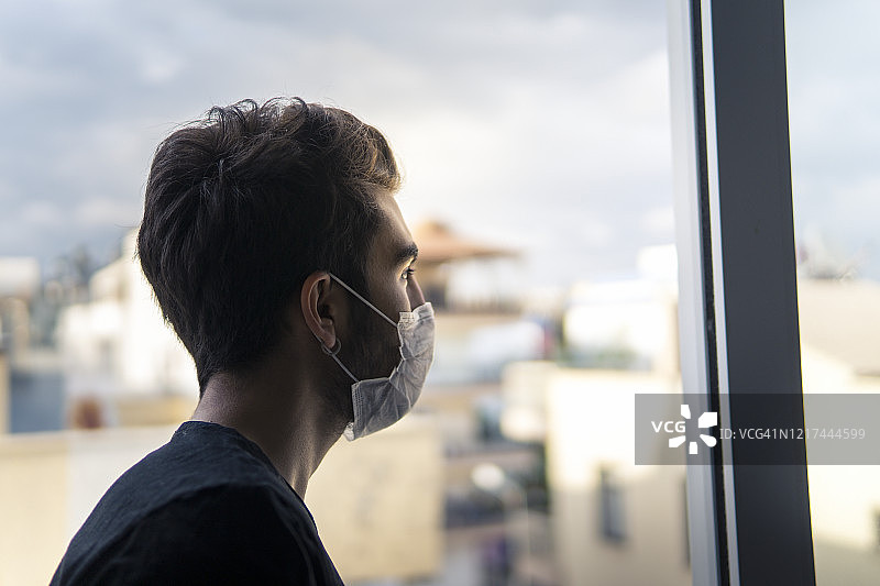 年轻男子戴着口罩自我隔离图片素材