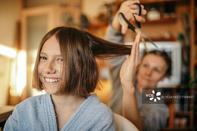 母亲在家给儿子剪头发图片素材