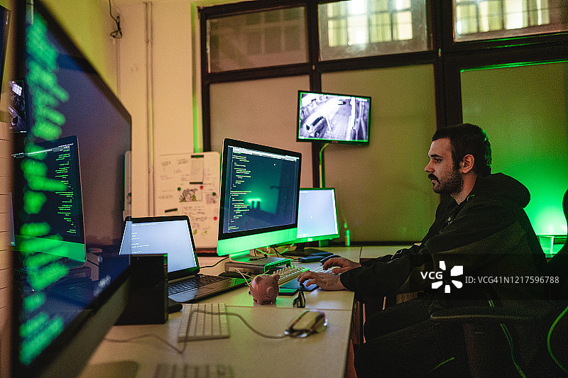 年轻的黑客在晚上操作电脑图片素材