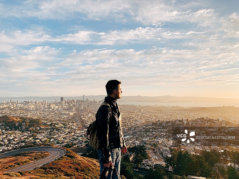 在日出时俯瞰美国加利福尼亚州旧金山天际线的年轻男人图片素材