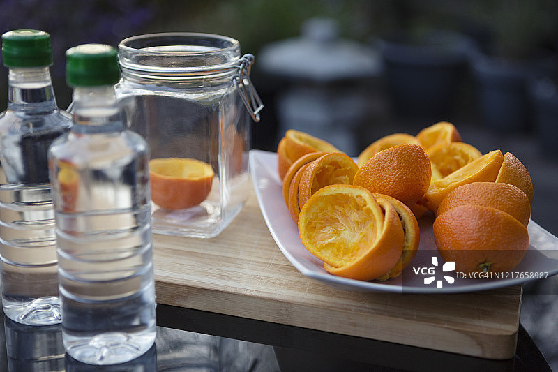 桌子上玻璃罐旁边的橙皮和白醋图片素材