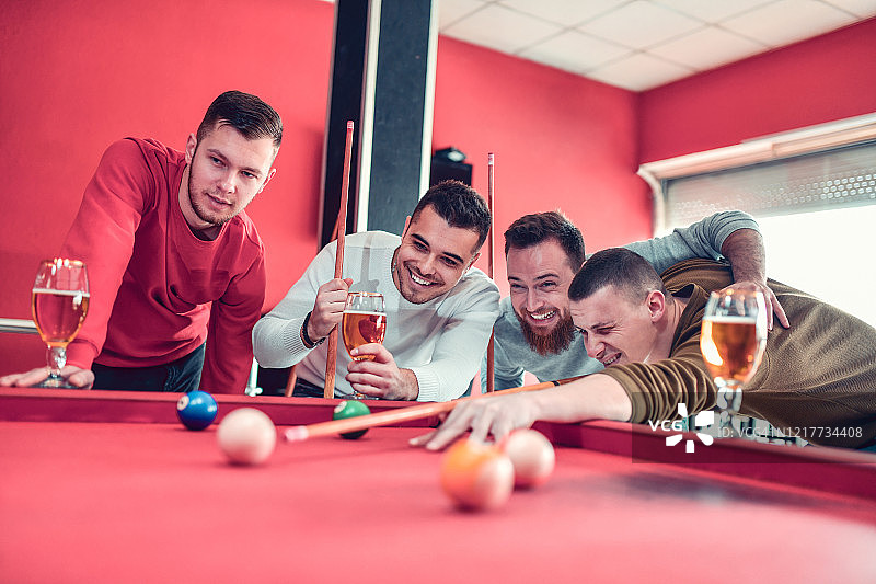 男人们观看朋友展示纯粹的斯诺克技巧图片素材