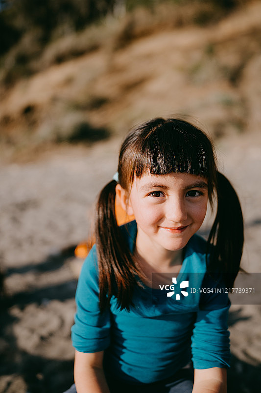 在海滩上对着镜头微笑的可爱少女图片素材