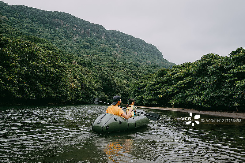父子在西表岛红树林河流中划充气筏（日本）图片素材