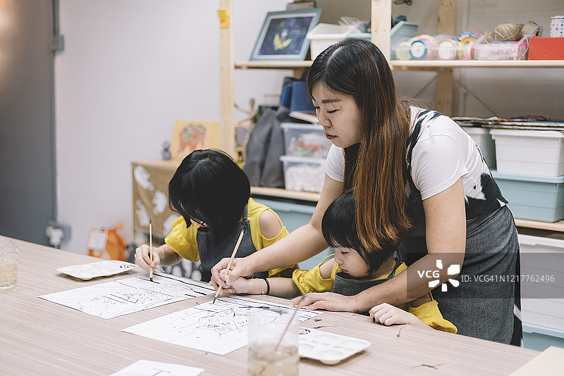 美术老师教中国孩子在画室绘画图片素材