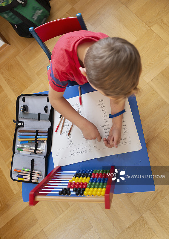 男孩在家中客厅学习，高角度视角图片素材