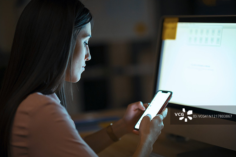 在办公室使用智能手机的年轻女人图片素材