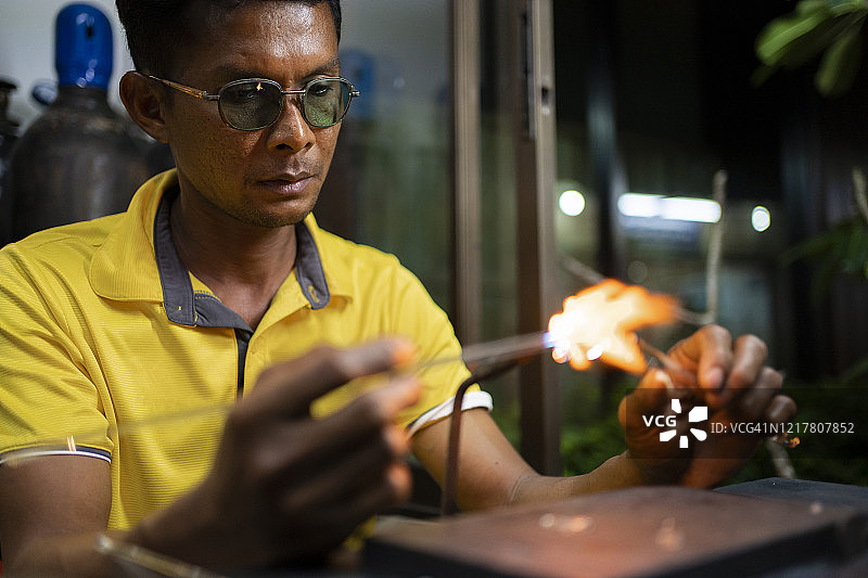 正在制作熔融玻璃的年长男人图片素材