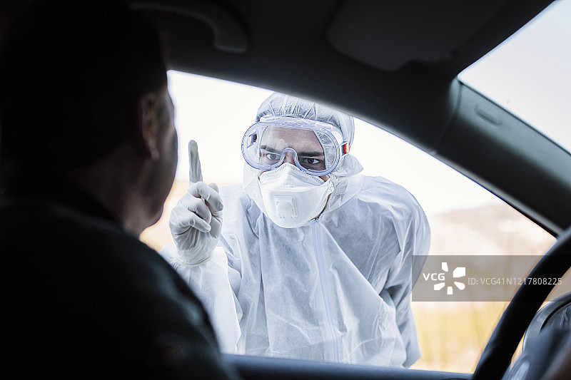 穿着防护服训斥车内老年男人的男人图片素材