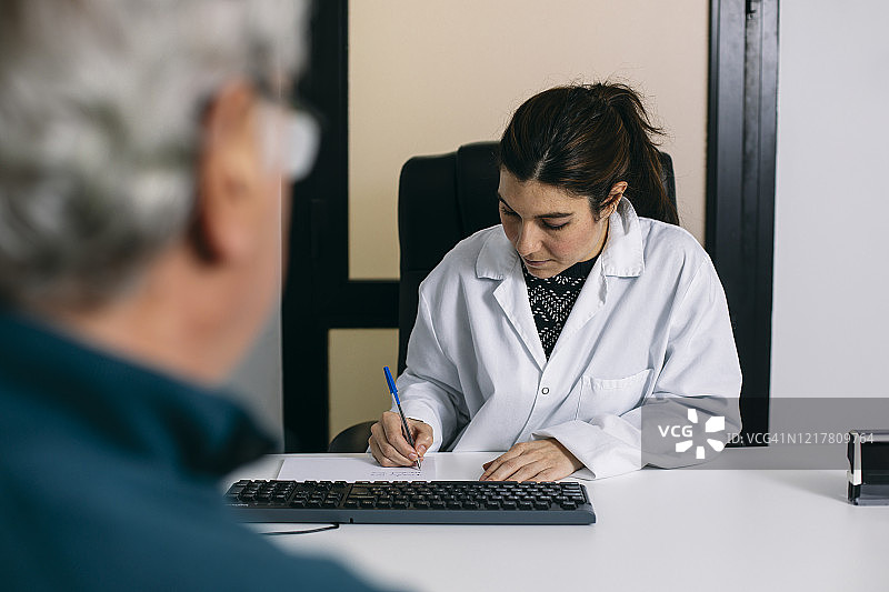 医生在医疗实践咨询中做笔记图片素材