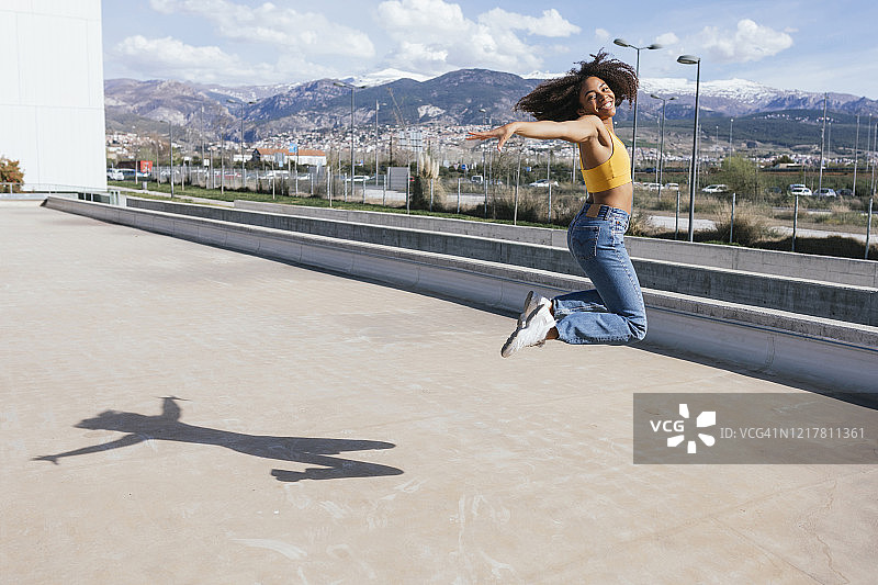 空中跳跃的快乐年轻女人肖像照片图片素材