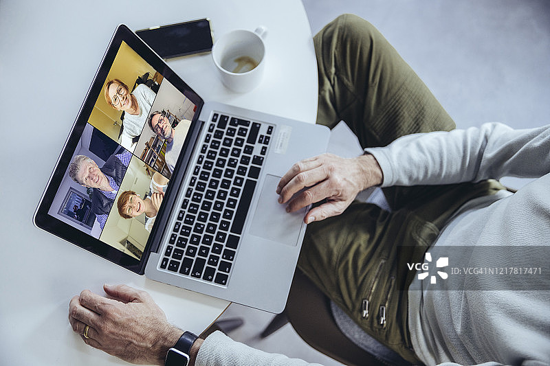 男人在家用笔记本电脑进行电话会议图片素材