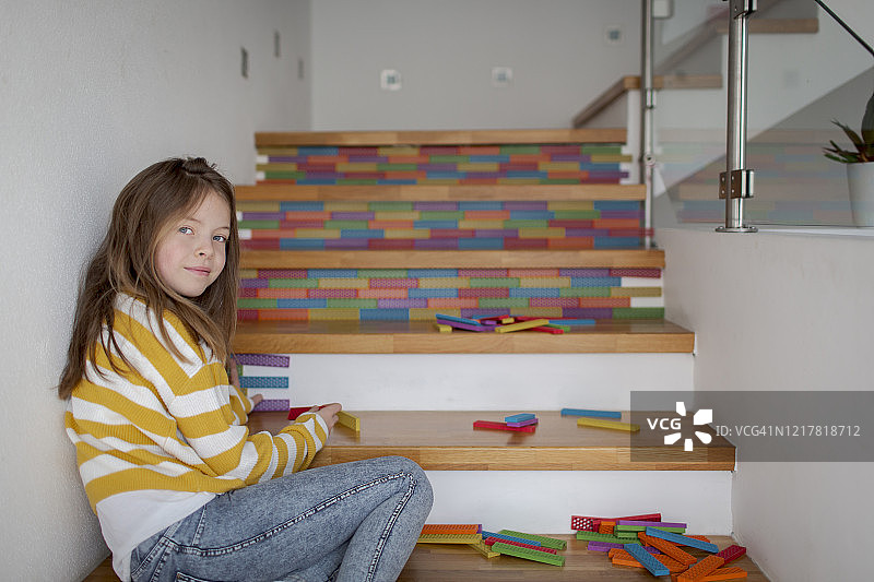 坐在楼梯上玩积木的女孩图片素材