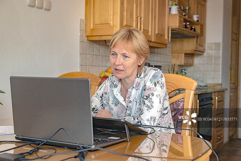 年长的数学老师使用笔记本电脑和绘图板授课图片素材