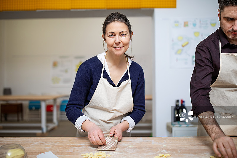 在烹饪课上学习制作新鲜意大利面的年长女性图片素材