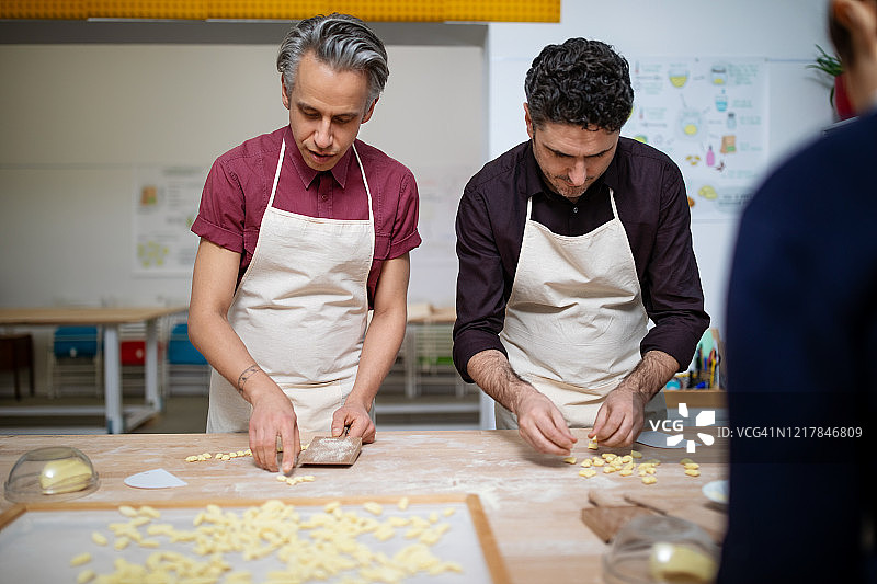 男士在烹饪课上学习制作手工意大利面图片素材