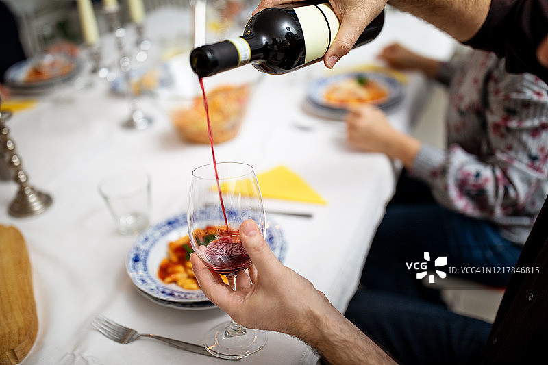 在餐桌上为客人倒酒的男人图片素材