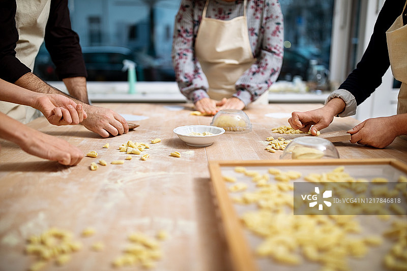 男女用面疙瘩板准备新鲜意大利面的手图片素材