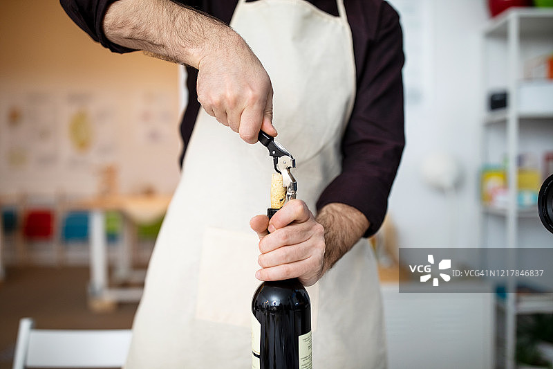 厨师用开瓶器打开葡萄酒瓶图片素材