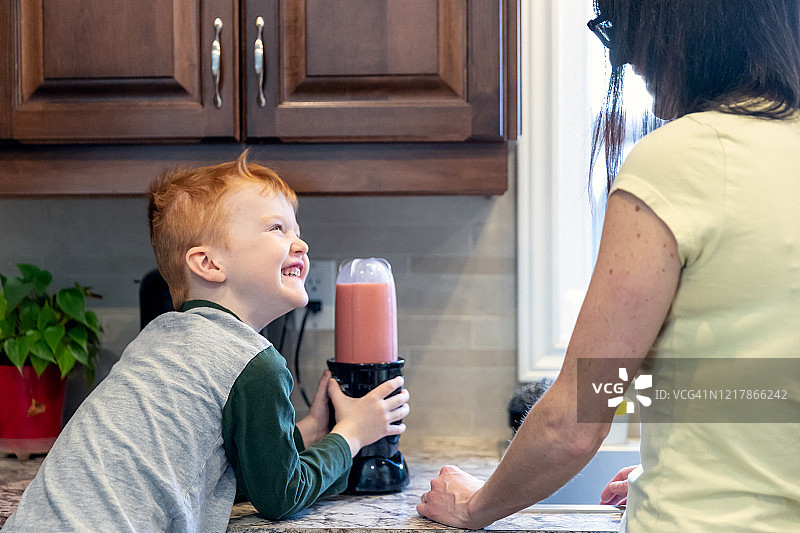 可爱的小孩在厨房帮助妈妈制作冰沙图片素材