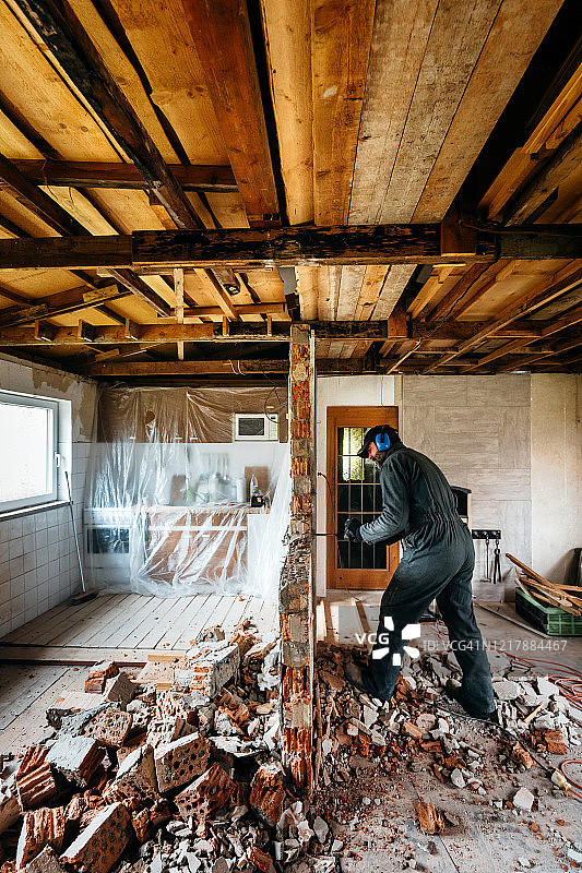 成熟工人在房子里损坏墙壁图片素材