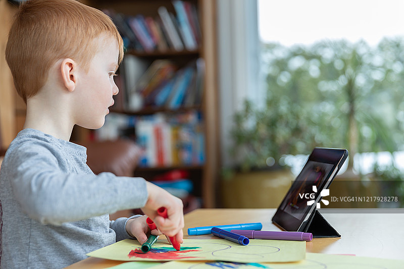 红发小男孩用数位板绘画图片素材