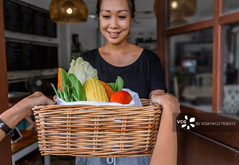 疫情期间快递员送新鲜有机蔬菜到客户家图片素材