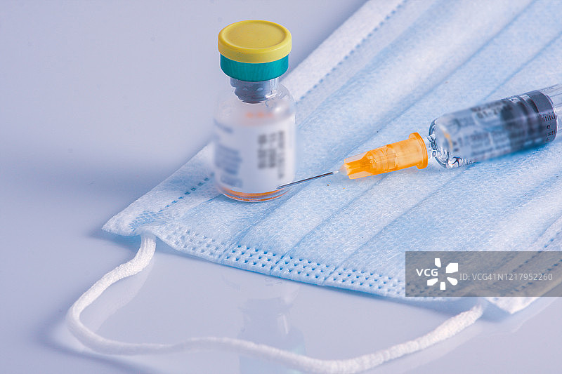 季节性流感疫苗：一次性塑料医用注射器和医用防护口罩图片素材