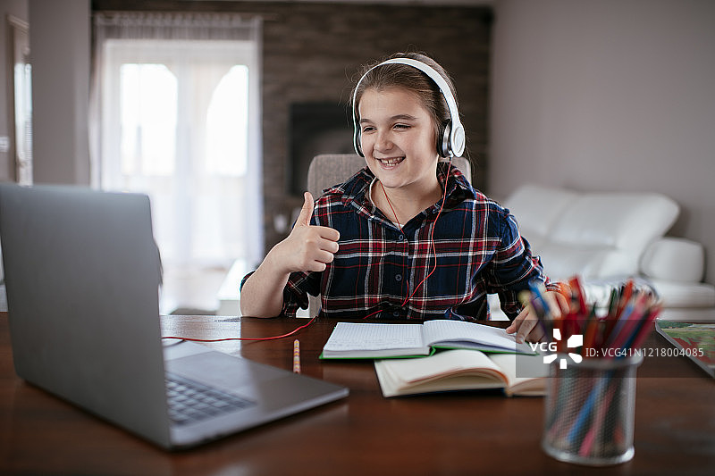 通过笔记本电脑进行视频通话的可爱少女照片图片素材