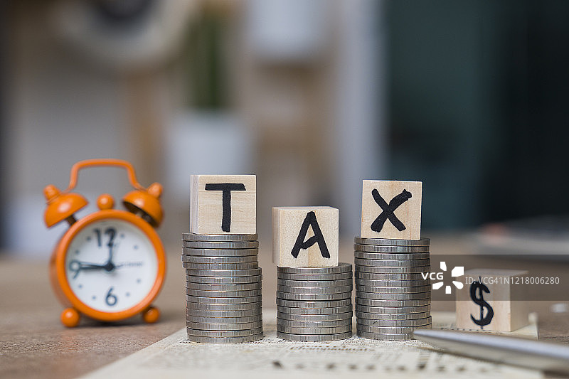 带有计算器和税务表格的木块上的税务字样图片素材