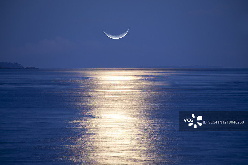 海面上升起的月牙图片素材