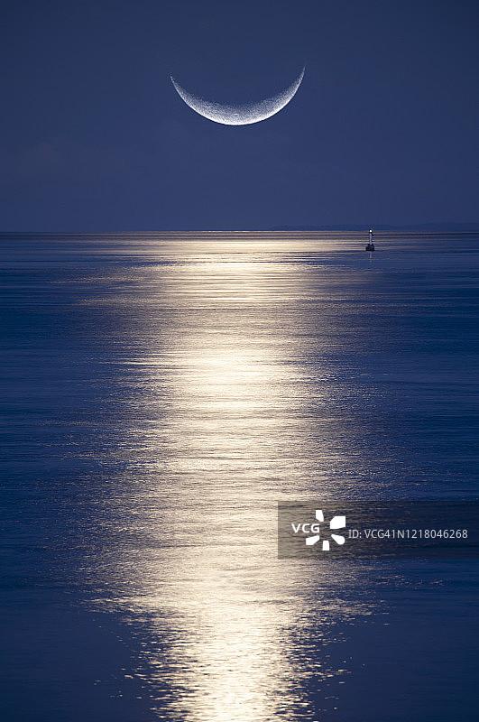 海面上升起的月牙图片素材