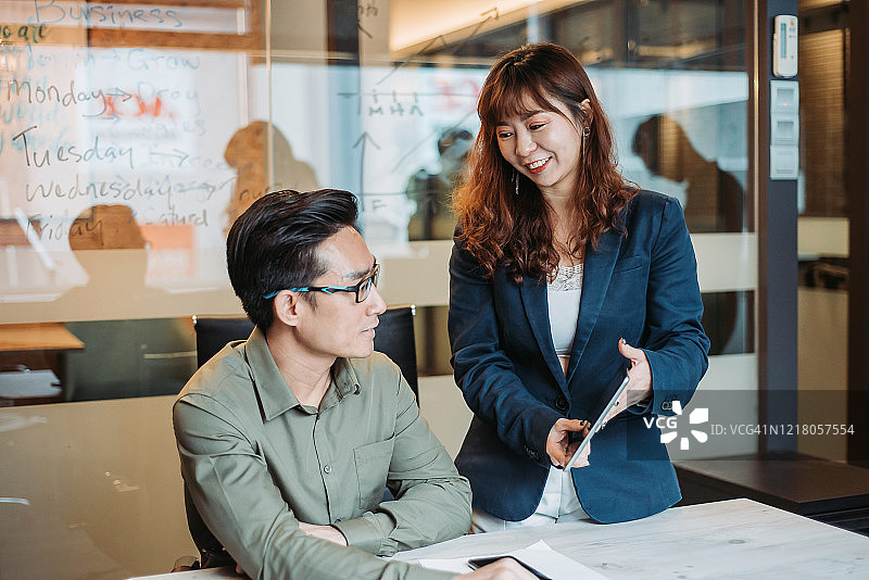 两名亚洲商人在办公室开会讨论图片素材