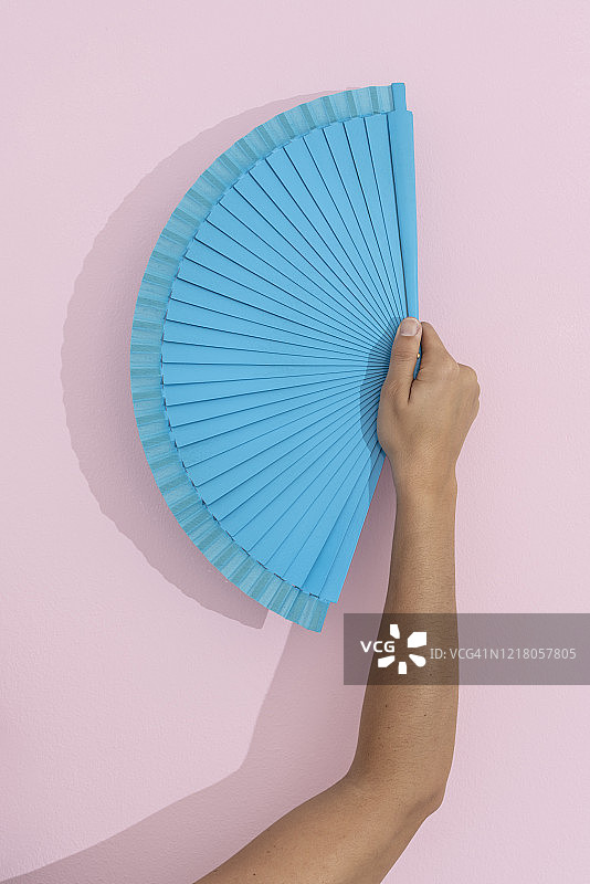 粉色背景上的蓝色折扇图片素材